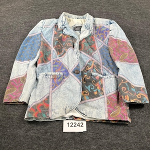 May include: A long-sleeve blazer featuring a patchwork design of acid-wash denim panels and sections of fabric with colorful paisley and floral patterns. The garment has a notched collar, a single dark button closure, and two front pockets.