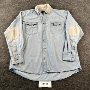 Op de afbeelding: Een lichtblauw overhemd met lange mouwen, voorzien van een beige corduroy kraag en bijpassende elleboogstukken. Het overhemd heeft twee borstzakken met knoopsluiting, een volledige knoopsluiting aan de voorzijde en manchetten met knopen.
