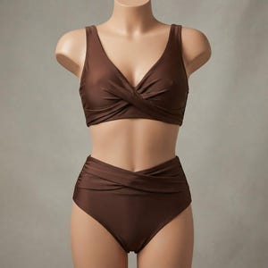 May include: A solid dark brown two-piece bikini set featuring a top with a V-neckline and a front twist detail, paired with high-waisted bikini bottoms that also include a matching front twist design across the waistband for a cohesive look.