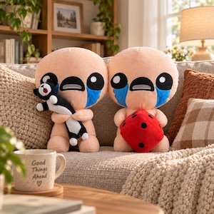 May include: Two plush toys with round beige heads, large black eyes, and blue tear-shaped patches on their cheeks. One toy holds a small black and white cat plush, while the other holds a red plush die with black dots. Both have simple, rounded bodies.