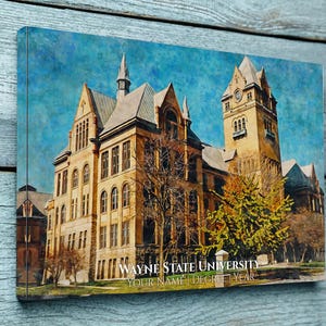 May include: A rectangular canvas print featuring a painterly depiction of a historic stone university building with a clock tower under a blue sky. The text WAYNE STATE UNIVERSITY, YOUR NAME, DEGREE, and YEAR is printed in white at the bottom.