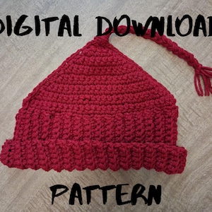 May include: A handmade, red crochet hat with a pointed top and a long braided tassel. The hat features a ribbed brim and is labeled "DIGITAL DOWNLOAD PATTERN" in black text.