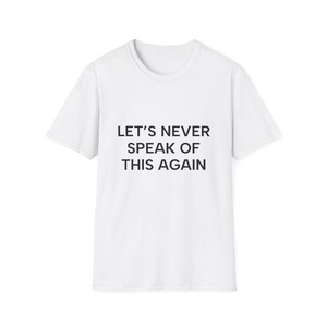 Puede incluir: Una camiseta blanca de manga corta con el texto negro LET'S NEVER SPEAK OF THIS AGAIN impreso en el centro del pecho. La prenda tiene un cuello redondo estándar y un dobladillo recto, ofreciendo una apariencia limpia y sencilla.
