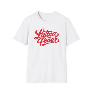 Puede incluir: Una camiseta blanca de manga corta con el texto Latina Power impreso en una llamativa letra cursiva roja en el centro del pecho. La prenda cuenta con un cuello redondo estándar, un diseño sencillo, mangas cortas y un dobladillo recto.