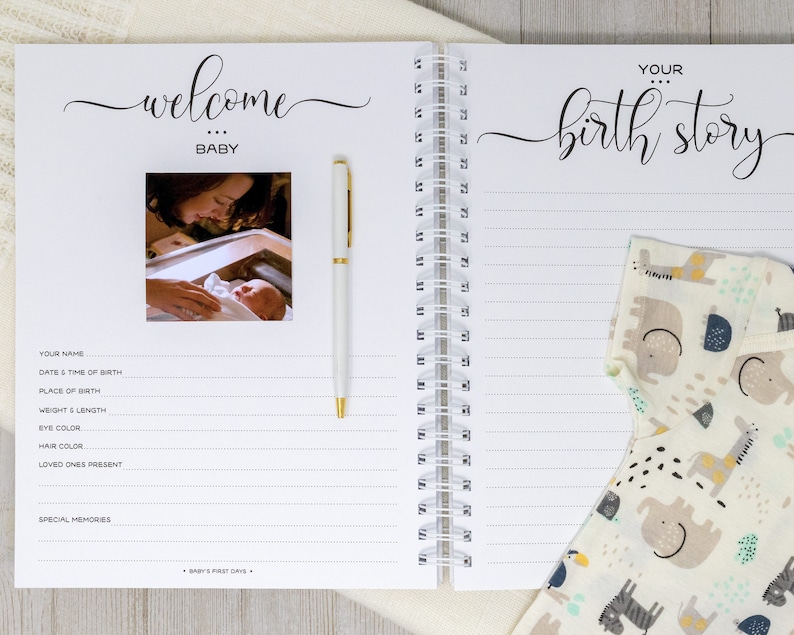 May include: A white baby journal with a spiral binding. The front cover has the words "welcome baby" in cursive script and a photo of a baby being held by a person. The back cover has the words "your birth story" in cursive script and a baby onesie with a colorful animal print.