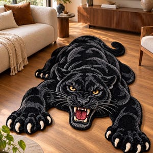 Può includere: Un tappeto tufted a forma di pantera nera ringhiante con pelo testurizzato nero e grigio scuro, occhi gialli penetranti, bocca aperta che rivela gengive rosse e denti bianchi, e artigli bianchi prominenti sulle zampe anteriori distese.