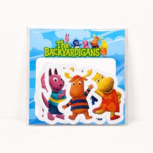 May include: A clear plastic package containing a set of stickers featuring The Backyardigans characters. The header card displays the show logo and colorful illustrations of the five main characters against a light blue sky with white clouds.