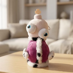 May include: A plush toy featuring a pale pink head with two large, bulging eyes and a small cross on top. The body is covered in a purple fabric with a white faux fur trim featuring black spots, and it has two small white arms with black markings.