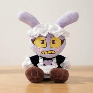 May include: A plush toy featuring a light purple rabbit character with long ears, yellow eyes, and a grumpy expression. It wears a black dress with a white ruffled apron, a white headpiece, and a purple heart patch. The feet are brown.