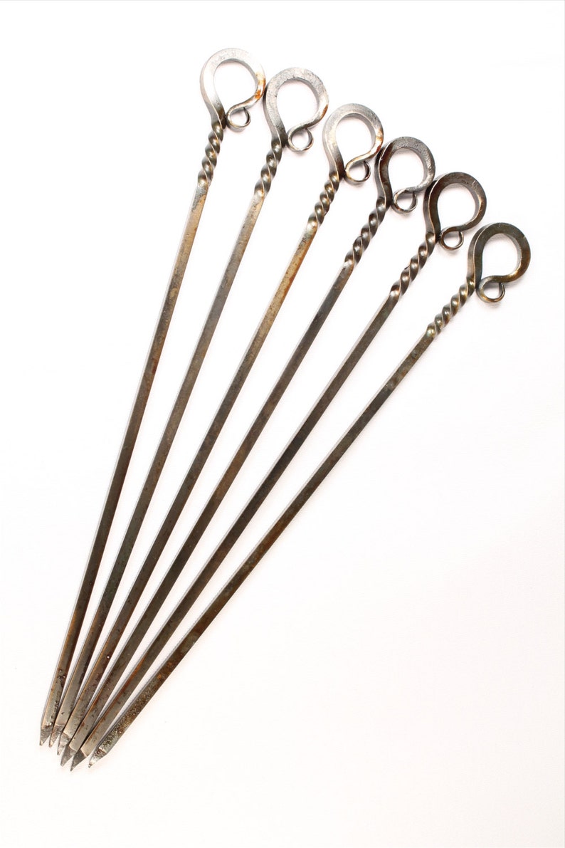 May include: Set of six metal skewers with twisted handles. Each handle has a loop at the top.