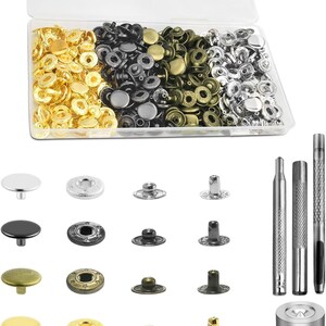 May include: A clear plastic storage box filled with metal snap fasteners in gold, black, bronze, and silver finishes. Below the box are individual snap components in matching colors, three metal setting tools, and a circular metal base tool.