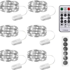 May include: Six coils of silver wire fairy lights, each connected to a white battery pack. Includes a white remote control with buttons for timer, mode, and dimming settings, plus a strip of six circular coin cell batteries for power.