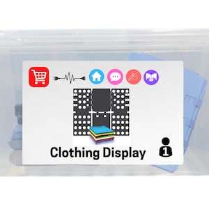 May include: A clear plastic storage bin featuring a white rectangular label on the front. The label displays the text Clothing Display, a shopping cart icon, various circular icons, a black grid pattern, and a stack of colorful folded shirts.