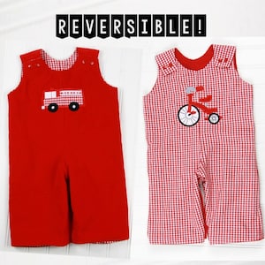 May include: Red and white reversible baby overalls with a fire truck and a tricycle design. The overalls are made of a soft, comfortable fabric and are perfect for everyday wear. "REVERSIBLE!" is written in black text at the top of the image.