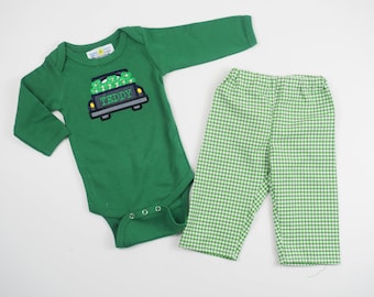Könnte beinhalten: Grüner Langarm-Body mit einem grünen LKW, der Kleeblätter transportiert, und dem Namen "Teddy", der auf der Vorderseite gestickt ist. Passende grüne und weiße Gingham-Hose.