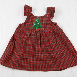 K&ouml;nnte beinhalten: Ein rotes und schwarzes kariertes, &auml;rmelloses Kleid mit einem gr&uuml;nen gestickten Weihnachtsbaum auf der Vorderseite.