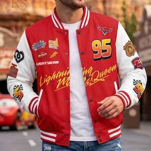 May include: A red and white varsity jacket featuring the number 95, the text Lightning McQueen, and various racing-themed patches including the Cars logo, Lightyear, and checkered flags. The jacket has a snap-button front and striped ribbed trim.