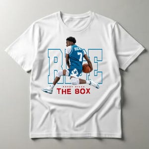 May include: A white short-sleeved t-shirt featuring a graphic of a basketball player in a blue jersey with the number 7 and the name RICE. The background includes the blue outlined text RICE and the red text RODDY RICCH THE BOX.