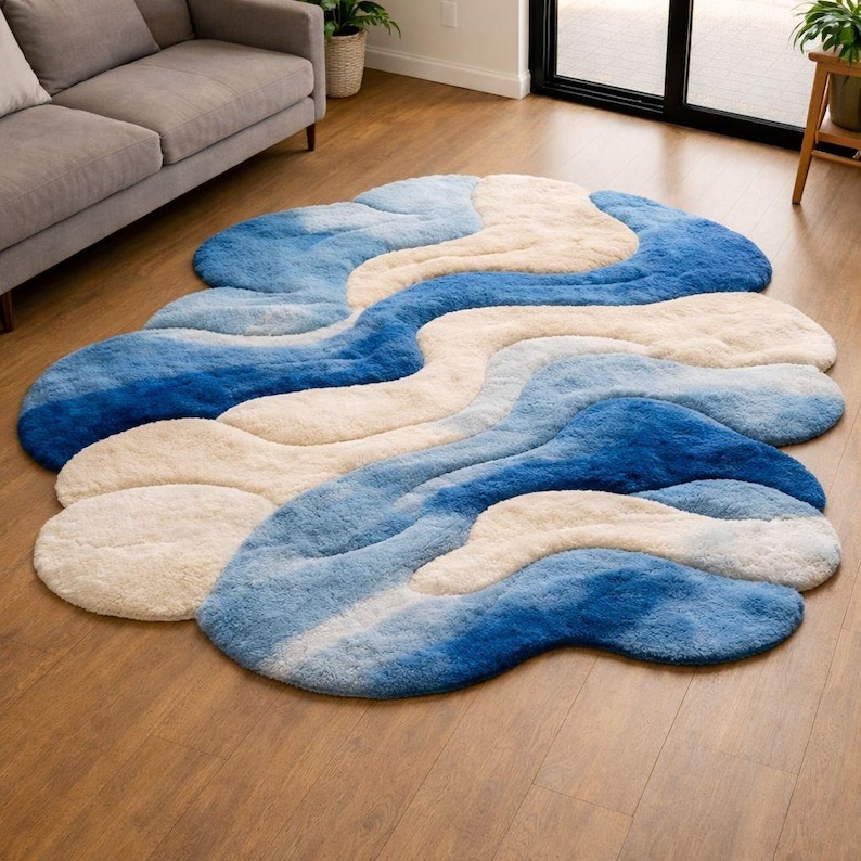 Hand tufted blue and ivory abstract area rug with flowing wave layers and organic curves made from New Zealand wool.