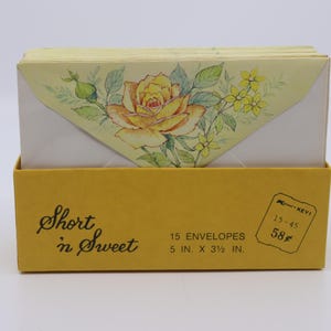 May include: A yellow box labeled Short 'n Sweet containing 15 envelopes measuring 5 inches by 3.5 inches. The envelopes feature a triangular flap decorated with a yellow rose and green leaves illustration. A price tag of 58 cents is visible.
