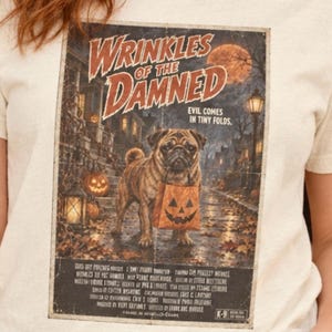 Könnte beinhalten: Ein cremefarbenes T-Shirt mit einem Grafikdruck mit dem Titel Wrinkles of the Damned. Das Design zeigt einen Mops, der eine Kürbis-Süßigkeitstüte auf einer nächtlichen Straße hält, mit dem Text Evil Comes in Tiny Folds und Film-Credits.