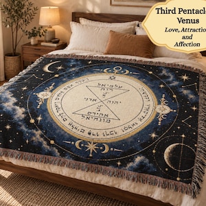May include: A woven throw blanket featuring a dark blue celestial background with stars and moon phases. The center displays the Third Pentacle of Venus with Hebrew text, geometric shapes, and symbols of love, attraction, and affection.