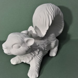 May include: White ceramic squirrel figurine with a curled tail. The squirrel is in a running pose with its head turned to the side.