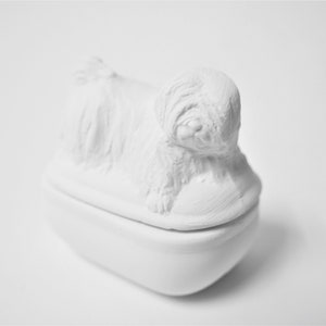 K&ouml;nnte beinhalten: Wei&szlig;e Keramik-Schmuckdose in Form eines Hundes, mit einem Deckel, der eine detaillierte Skulptur eines liegenden Hundes zeigt.
