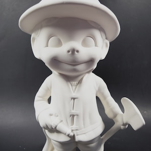 May include: White ceramic figurine of a firefighter with a hat, holding an axe and a hose. The figurine is ready to put out a fire.