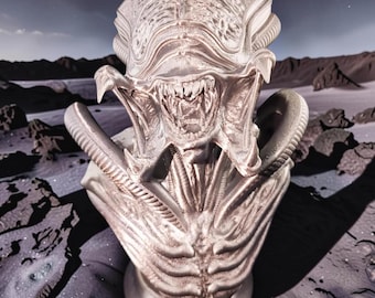 May include: A metallic silver-toned bust of a creature with an elongated, ribbed cranium, a wide jaw revealing sharp teeth, and a textured, segmented torso. The sculpture features intricate, organic-looking ridges and deep grooves throughout.