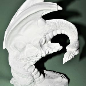 May include: White ceramic dragon figurine with wings outstretched and tail curled around its body. The dragon is perched on a rocky base.