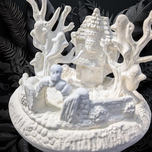 May include: White ceramic figurine of a spooky house with trees and a ghost. The house has a detailed roof and windows. The trees have branches that look like spooky hands. The ghost is standing in front of the house.