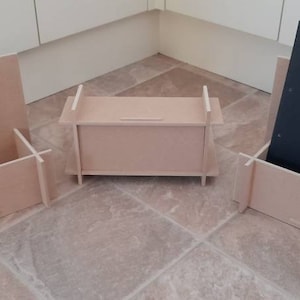 May include: Three unfinished wooden organizers. One holds a black notebook with "NOTES" printed on it. The other two are open boxes. The organizers are made of light-colored wood and are designed to hold items.