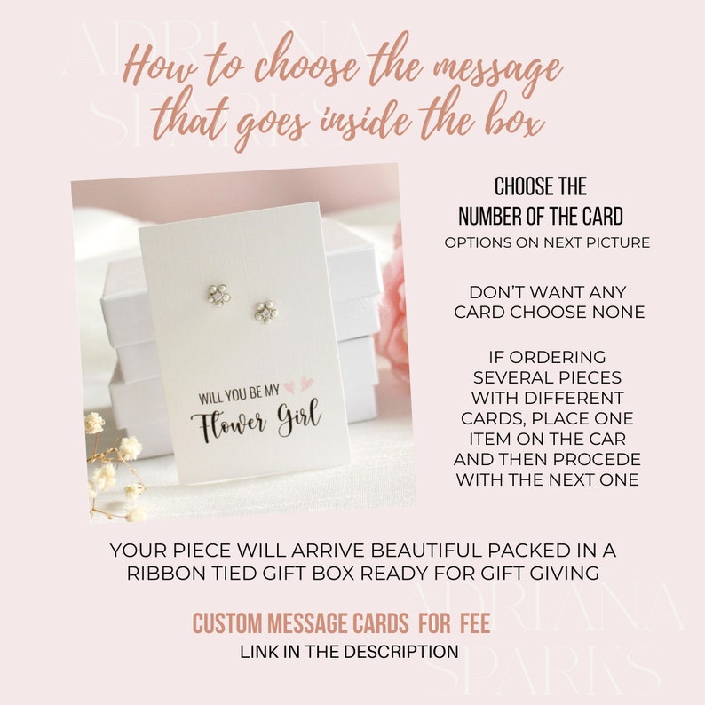 Op de afbeelding: Een witte cadeaudoos met een roze lint eromheen. De doos bevat een paar zilveren oorbellen met kleine bloemcharms. Een kaartje in de doos staat "Will you be my Flower Girl".