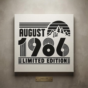 May include: A square canvas print featuring black text and graphics on a white background. The design includes the words AUGUST EST 1986 LIMITED EDITION, a mountain silhouette, and a sun graphic. A small gold plaque below reads August 1986 Limited Edition Collection.