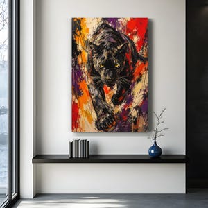 May include: A rectangular wall art print featuring a black panther in a forward-facing stance. The artwork uses a vibrant, abstract paint splatter style with bold splashes of red, orange, yellow, and purple against a dark, textured background.