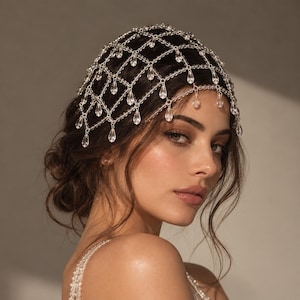 May include: A silver-toned headpiece featuring a delicate lattice chain design adorned with numerous clear, teardrop-shaped crystals that hang from the intersections of the grid, creating a draped, shimmering effect over the top of the head.