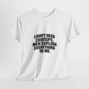Op de afbeelding: Een wit T-shirt met korte mouwen en zwarte tekst op de borst met de tekst: I DON'T NEED CHATGPT, MEN EXPLAIN EVERYTHING TO ME. Het kledingstuk heeft een ronde hals en een standaard pasvorm, wat zorgt voor een eenvoudig en strak ontwerp.