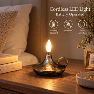 May include: A cordless LED light with a black and gold distressed finish, featuring a candle-shaped bulb and a circular handle. Text on the image reads: Cordless LED Light, Battery Operated, Battery Operated, No Wires, Place Anywhere.
