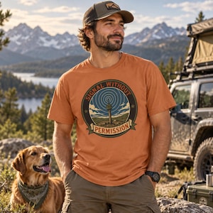May include: A burnt orange short-sleeve t-shirt featuring a circular graphic on the chest. The graphic depicts a radio tower emitting signal waves against a blue sky and landscape, with the text "SIGNAL WITHOUT PERMISSION" printed around it.
