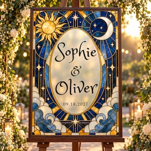May include: A rectangular wedding sign in a dark wood frame featuring a stained glass design with a sun and moon. The center oval displays the text Sophie & Oliver and the date 09.18.2027 in black script against a cream background.