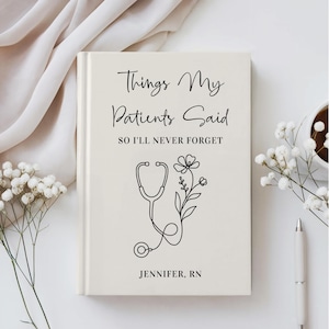 May include: A cream-colored hardcover journal with black text that reads Things My Patients Said SO I'LL NEVER FORGET and JENNIFER, RN. The cover features a black line art illustration of a stethoscope intertwined with a floral stem.