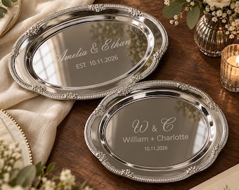 Puede incluir: Dos bandejas ovaladas de metal plateado con bordes de cuentas ornamentados. La bandeja más grande está grabada con "Amelia & Ethan" y "EST 10.11.2026". La bandeja más pequeña está grabada con "W & C", "William + Charlotte" y "10.11.2026".