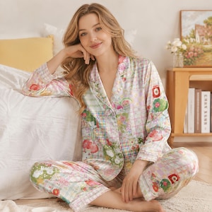 Può includere: Un set di pigiama a maniche lunghe composto da una camicia abbottonata con colletto a revers e pantaloni coordinati. Il tessuto presenta un motivo patchwork multicolore con quadri pastello, disegni floreali e piccole fragole rosse.