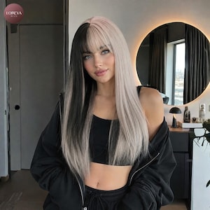 May include: A long, straight wig featuring a split-color design with one side in solid black and the other in platinum blonde. The wig includes straight-cut bangs that frame the forehead, with the hair falling past the shoulders in a sleek style.