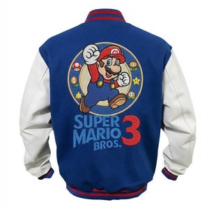 Può includere: Una giacca varsity blu con maniche bianche e bordi a righe rosse. Il retro presenta un ricamo di Mario all'interno di una cornice circolare, circondato da piccole icone di gioco, con il testo Super Mario Bros. 3 stampato in blu e rosso.