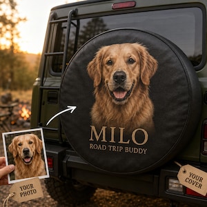 May include: A black circular spare tire cover mounted on the back of a dark green vehicle. The cover features a large, realistic portrait of a golden retriever dog with the text MILO and ROAD TRIP BUDDY printed in a light tan color below the dog.