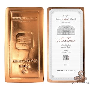 May include: A rectangular copper bullion bar with a polished finish, embossed with the text GEIGER EDELMETALLE, SCHLOSS GÜLDENGOSSA, and FEINKUPFER 999,9 5000 g. Beside it is a white certificate of authenticity featuring the same building illustration.