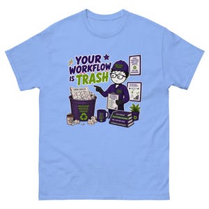 Puede incluir: Una camiseta azul claro con una ilustración de dibujos animados de un ingeniero industrial señalando un cubo de basura con la etiqueta "Inefficient Wasteful Chaotic" y el texto "YOUR WORKFLOW IS TRASH". El diseño incluye libros y gráficos.
