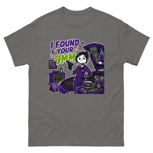 Puede incluir: Una camiseta gris carbón con un gráfico de un mecánico con mono morado sosteniendo una pistola. El texto dice I FOUND YOUR 9MM, MECHANICS FIX PROBLEMS YOU CAN'T, I BREAK IT I FIX IT I REPEAT, GOOD HANDS SAVE ENGINES y CAFFEINE > COMPLAINING.